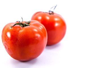 Multiple tomatoes on white background.