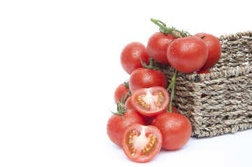 Fresh ripe vine tomatoes in rustic basket with sliced tomato iso