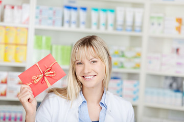 lächelnde apothekerin mit gutschein