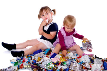 Two little girls in candy wrappers from sweets