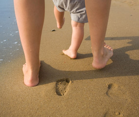 Mother and child walking on a sandy beach