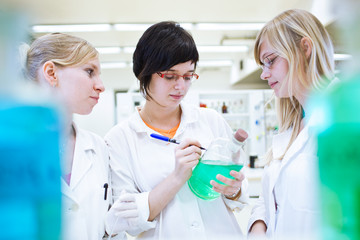 three researchers/chemistry students in a lab