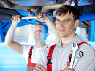 Motor mechanic is satisfied with his job in a garage
