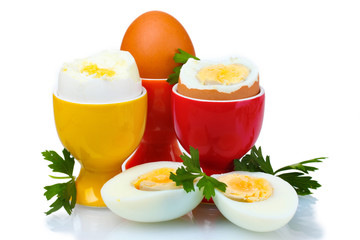 Boiled eggs in bright stands and parsley isolated on white