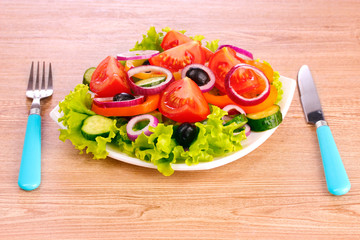 many vegetables on the plate on a wooden background
