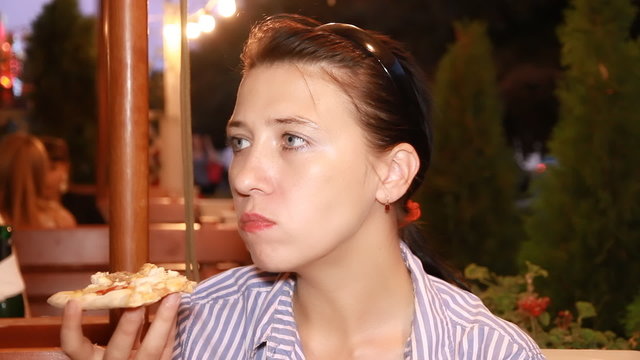 Woman eats pizza in cafe