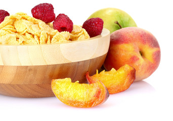 tasty cornflakes and fruit in wooden bowl isolated on white