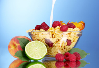 tasty cornflakes, fruit and milk in glass bowl