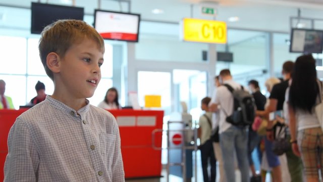 Boy talks to somebody near passport control at airport