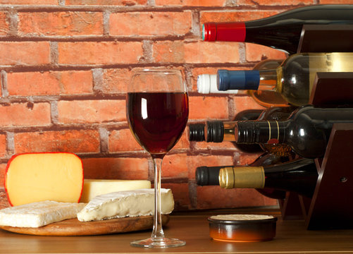 Wine rack , glass of wine and cheese