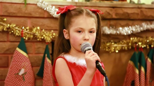 Girl sings Christmas song into microphone