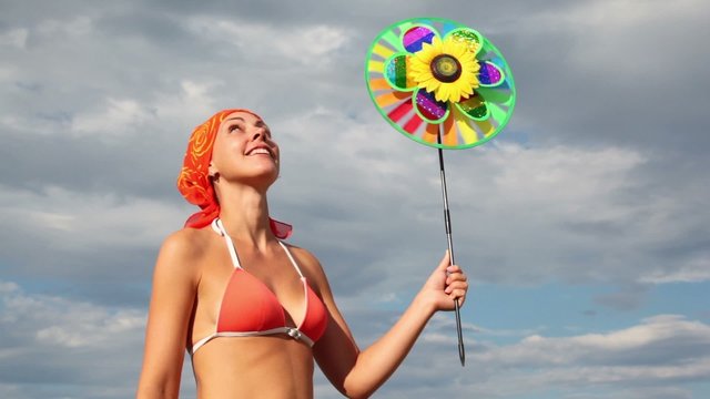 woman holding toy that spins on background of sky