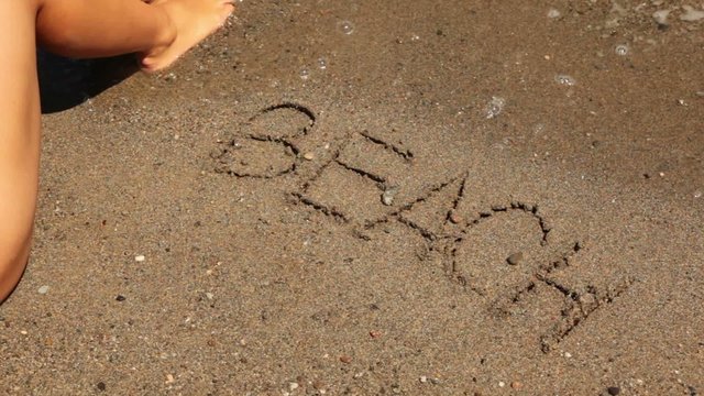 word beach is written on sand, sea wave appear