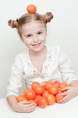 Happy little girl with orange mandarins