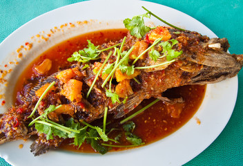 Fried grouper fish with sauce,sour and spicy on white plate,Thai