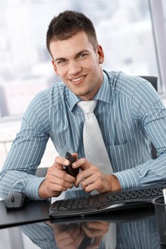 Portrait of young businessman sitting at desk