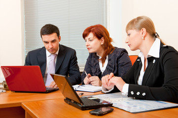 Three business people are meeting