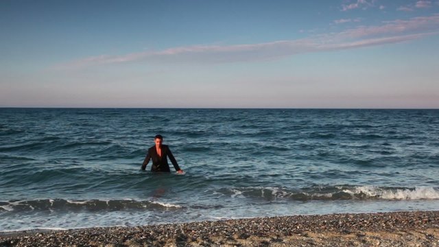 Man in wet suit going out from sea water