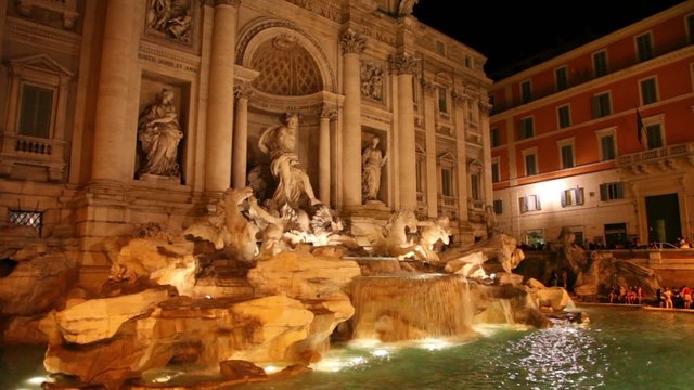 Trevi Fountain at evening, some tourists watching waterfall