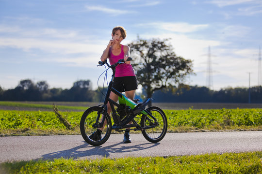 sportliche Frau mit Streetstepper auf Radweg