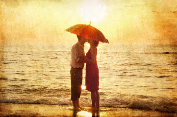 Couple kissing at the beach in sunset.