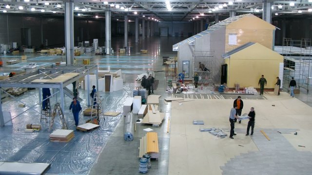 Workers disassemble the exhibition stands