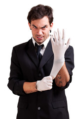 irrer Mann zieht Latexhandschuhe an