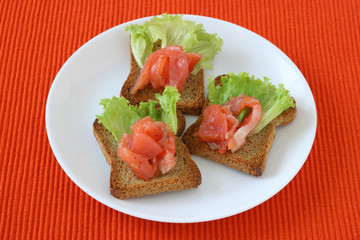 toasts with salmon on a plate