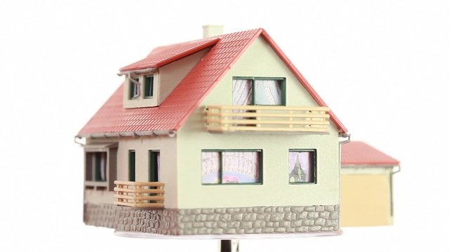 Little toy house turning around on transparent platform