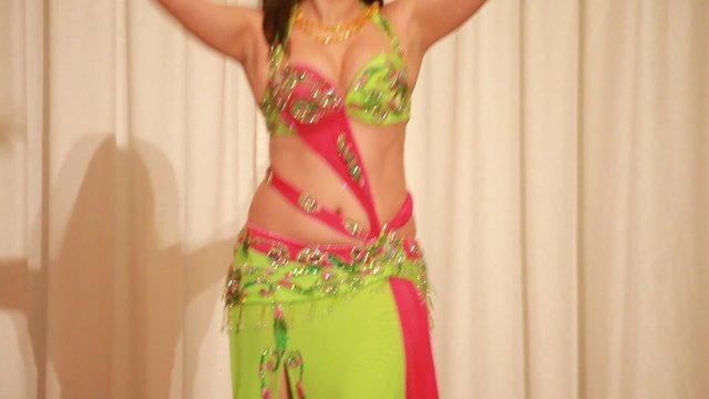 Young female in green perform bellydance