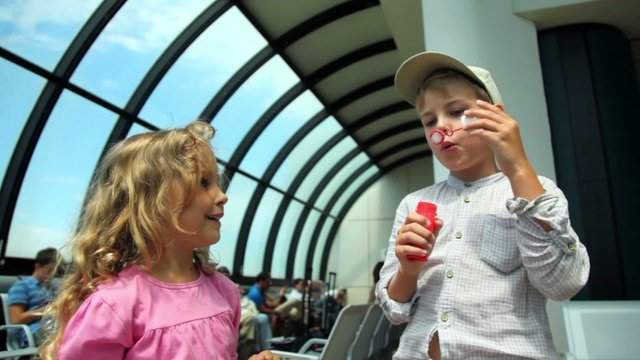 Two kids boy and girl get fun play bubble