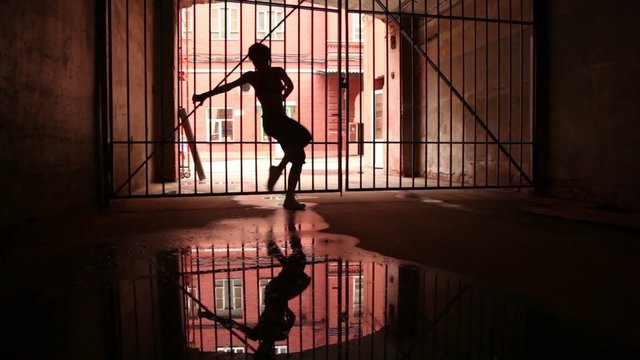 woman performs modern dance near lattice gate