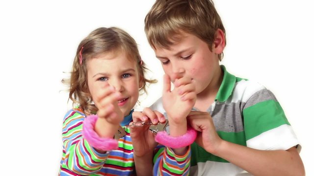 Two children plays with furry handcuffs