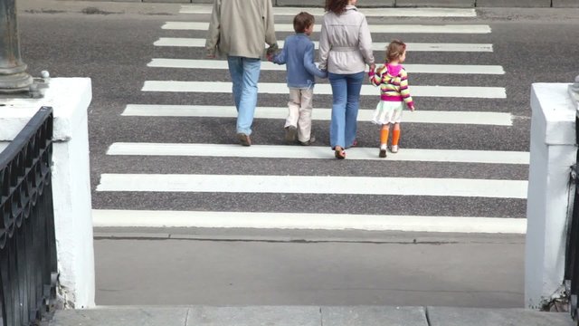 Family stand at edge of pedestrian crossing road