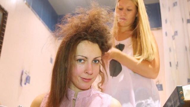 The hairdresser does a hairdress to young woman