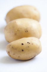 bunch of potatoes on white background close up shoot