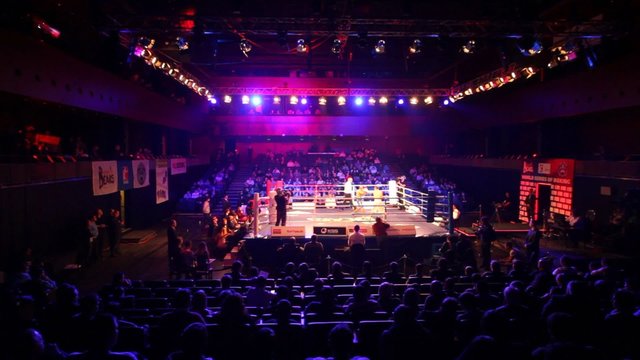 Boxing match is in illuminated hall