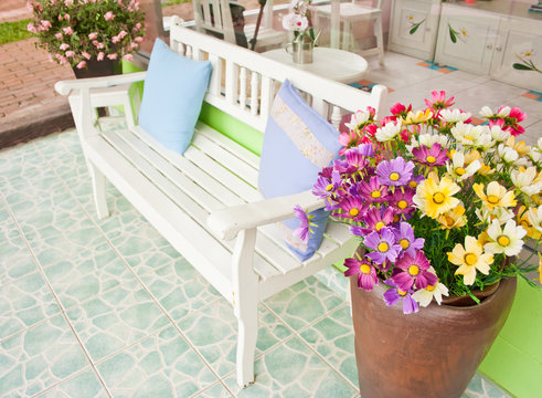 white armchair setting  with flowerpot at balcony