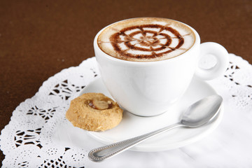 Hot latte, a cup of hot latte flower art  with cookie.
