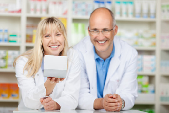 zwei kollegen in der apotheke zeigen ein medikament