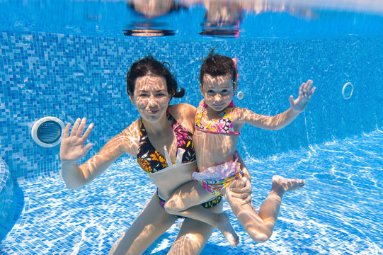 Underwater smiling family in swimming pool