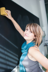 pretty young college student erasing the chalkboard