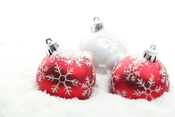 Red and white christmas balls in snow flakes
