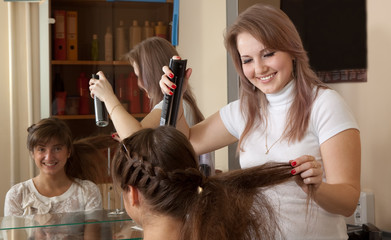 Fototapeta premium hairdresser works on woman hair