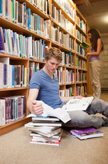 Portrait of a male student making research while his classmate i