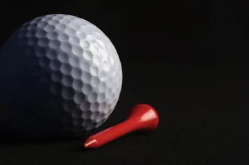 Papier Peint photo autocollant Sports de balle Golf ball with red tee on black background