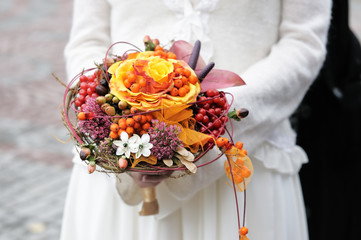 Bride holding beautiful orange wedding flowers bouquet