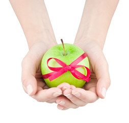 Apple with ribbon in women's hands