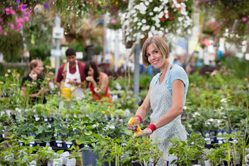 Beautiful woman spraying water on plants