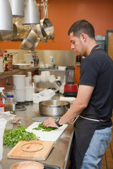 Sous chef preparing cilantro in professional kitchen